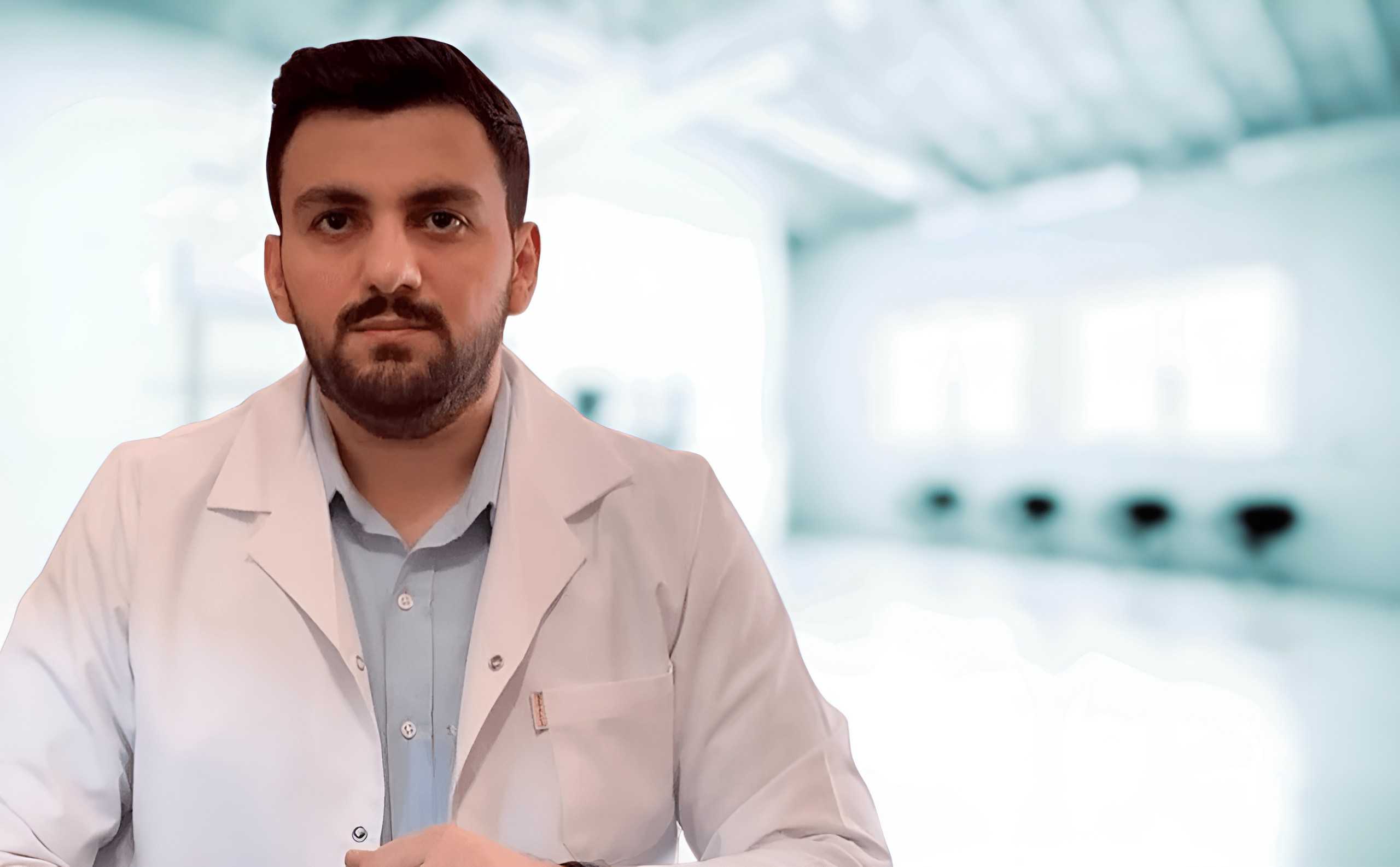 Ağ xalatda və stetoskopla həkim kameraya gülümsəyir